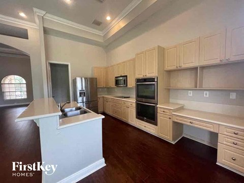 A kitchen with wooden cabinets and a white island.