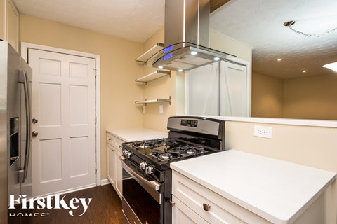 A kitchen with a stove top oven and a refrigerator.