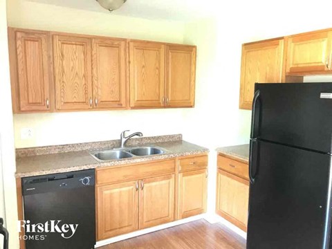 a kitchen with wooden cabinets and a black refrigerator