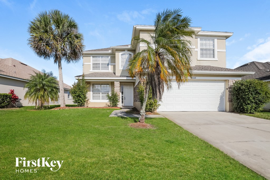 a home with two palm trees in front of it