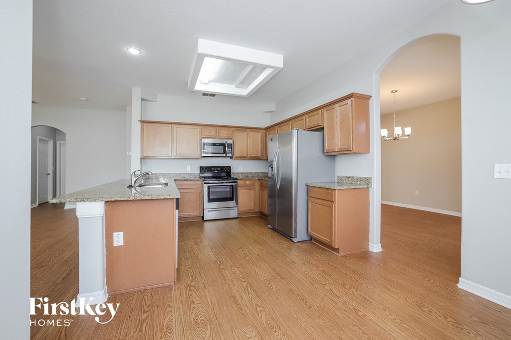a kitchen with wood flooring and stainless steel appliances