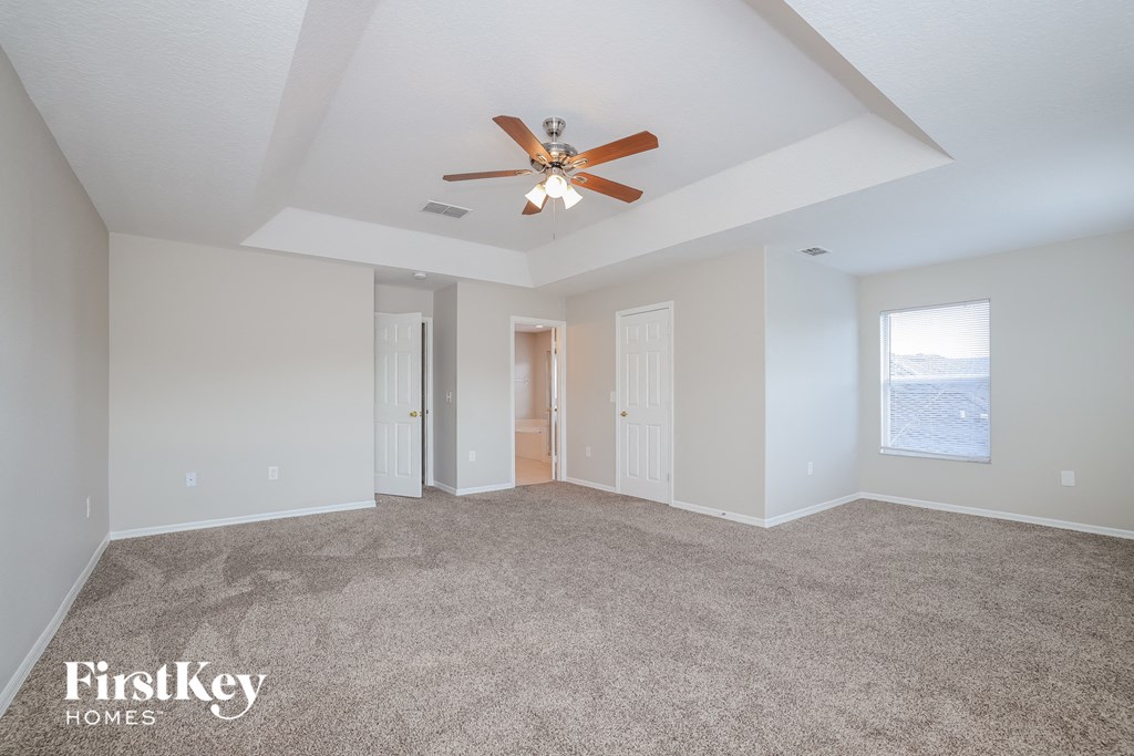 a living room with carpet and a ceiling fan