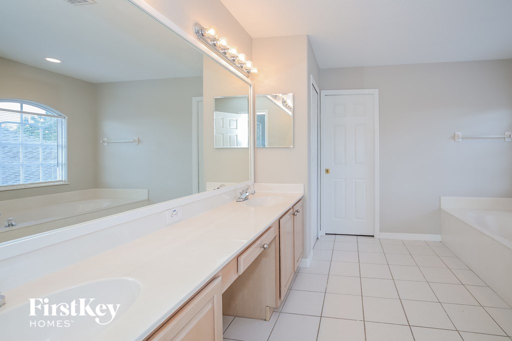 a bathroom with a long counter top and a large mirror
