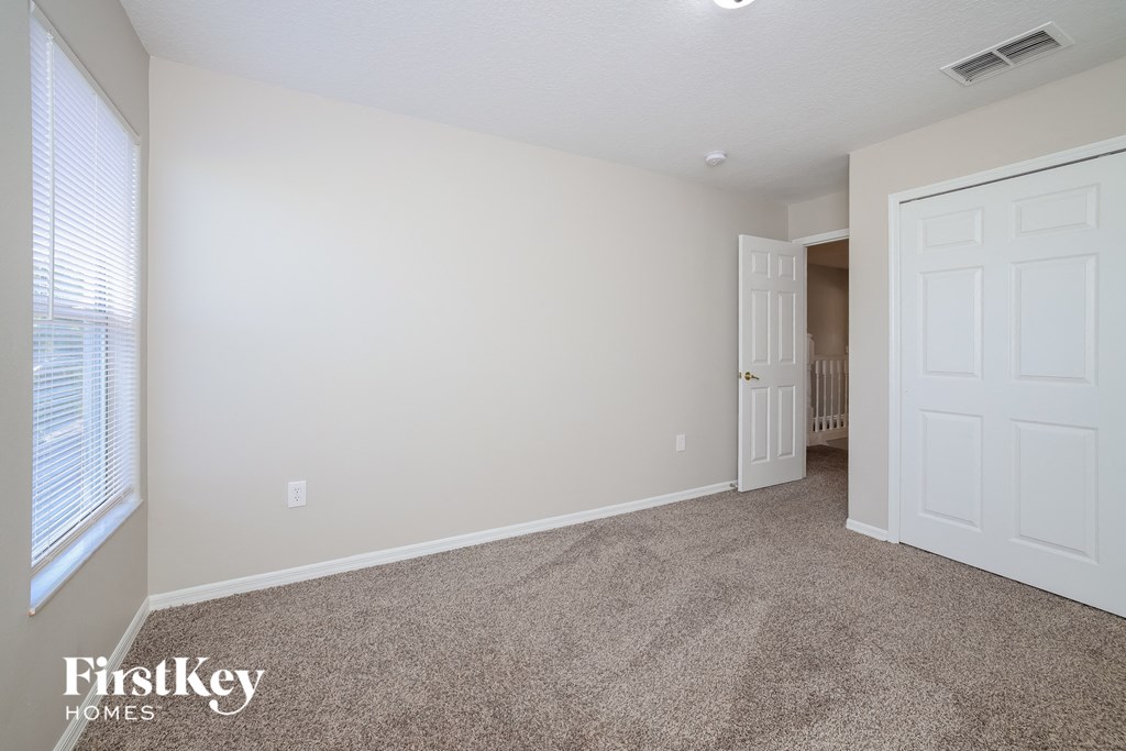 a bedroom with a carpeted floor and a white door