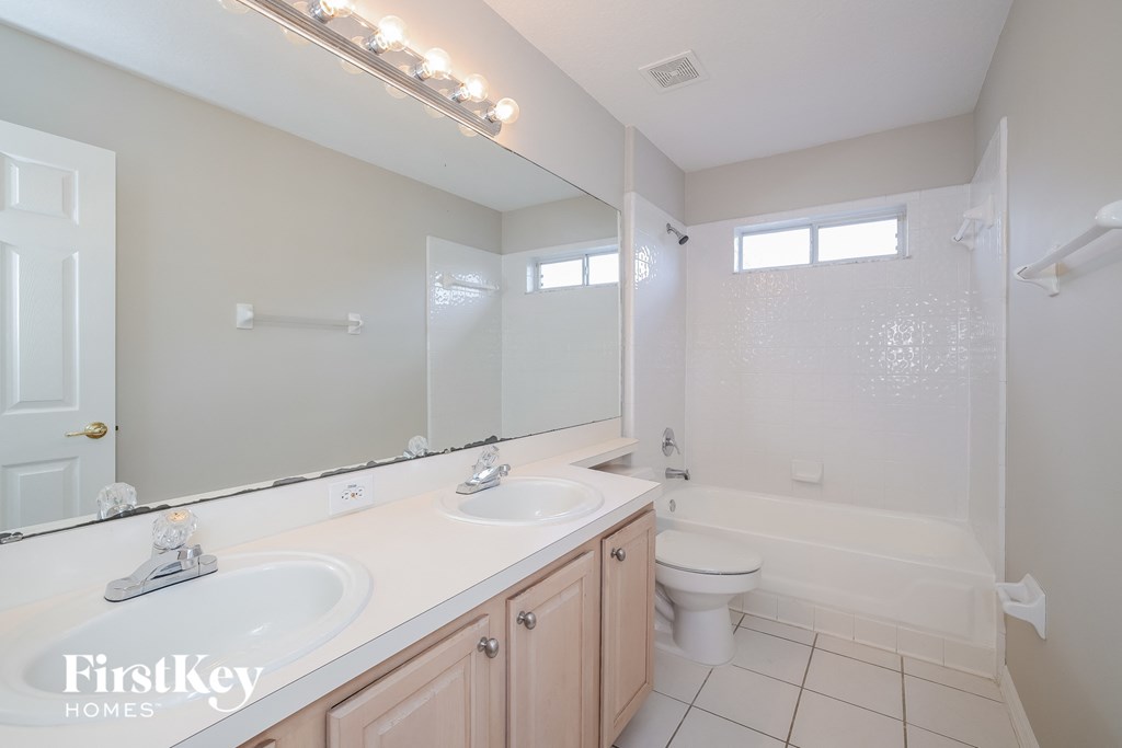 a bathroom with two sinks and a toilet and a shower