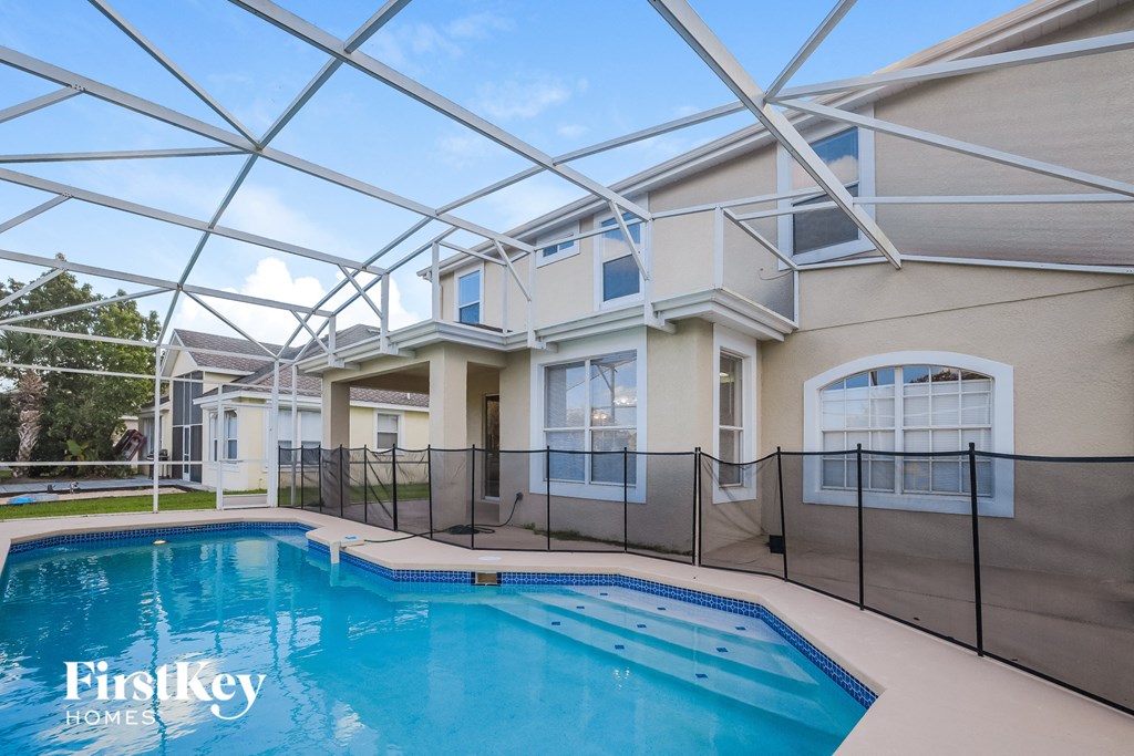 a large swimming pool in front of a house with a pool