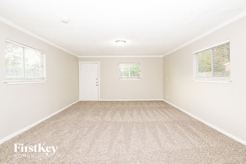 A room with a carpeted floor and a door in the middle.