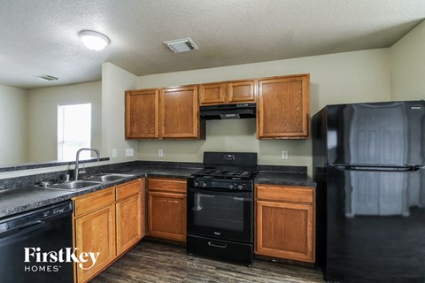 a kitchen with black appliances and wooden cabinets
