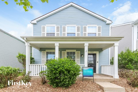 a blue house with a porch and a blue chair in front of it