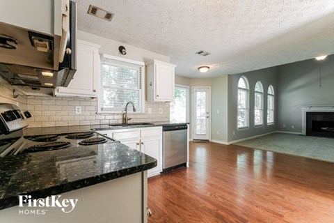A kitchen with a black counter top and white cabinets.