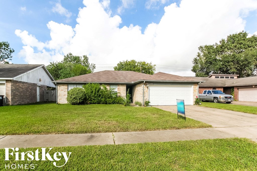 a home in a neighborhood with a lawn and a blue mailbox