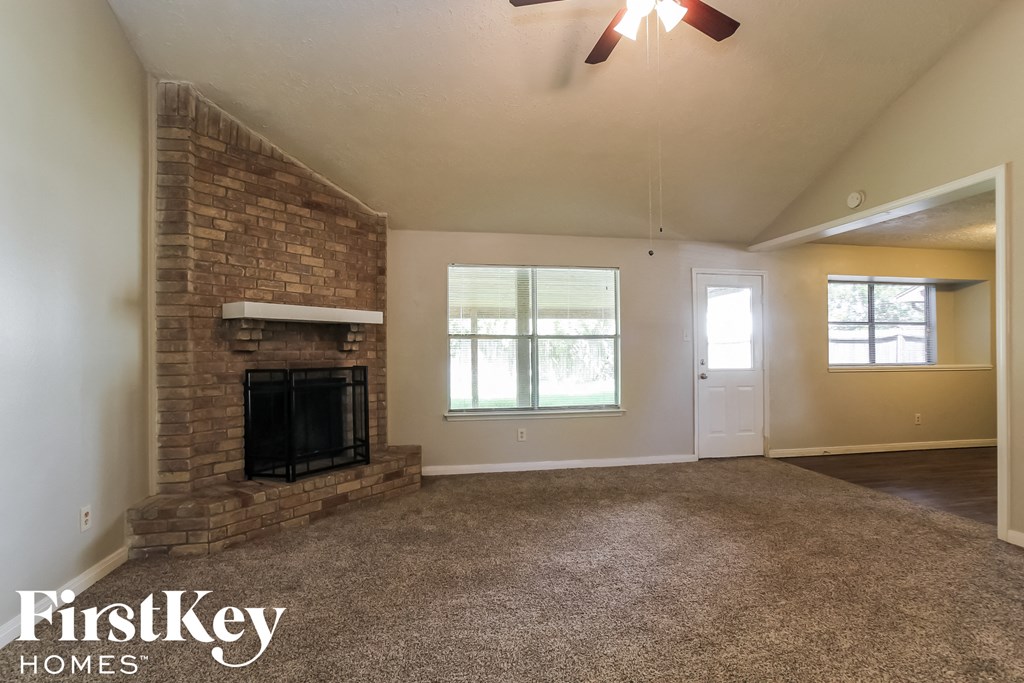the living room of an empty house with a brick fireplace