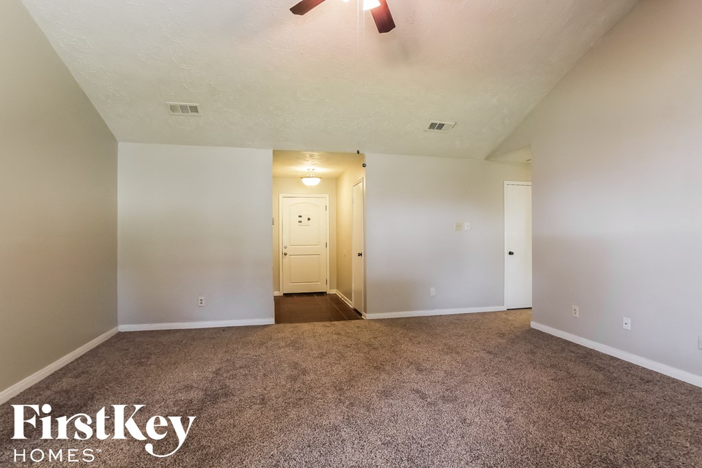 an empty living room with carpet and white walls