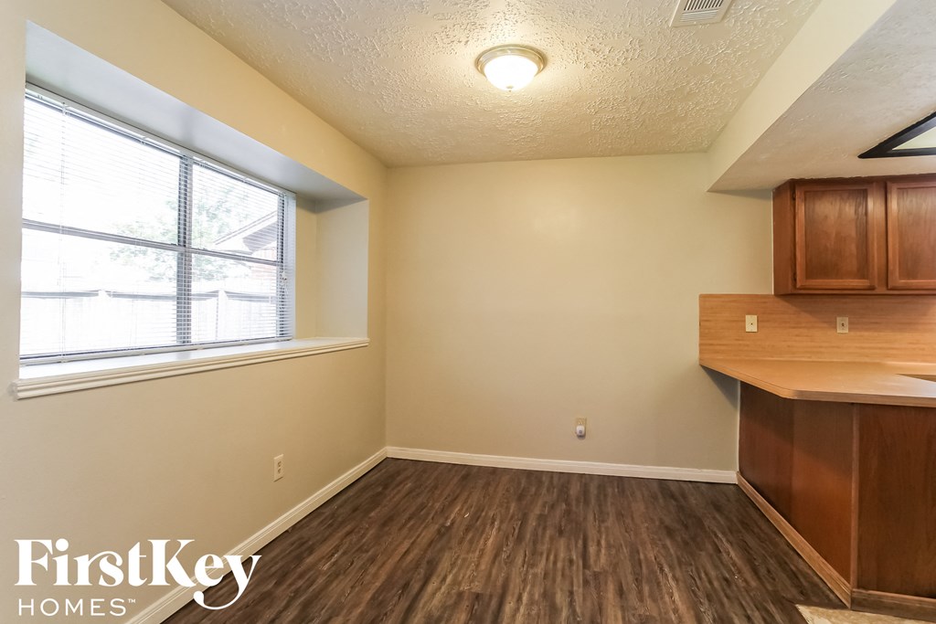 the kitchen and dining area of a small house with wood flooring and a window