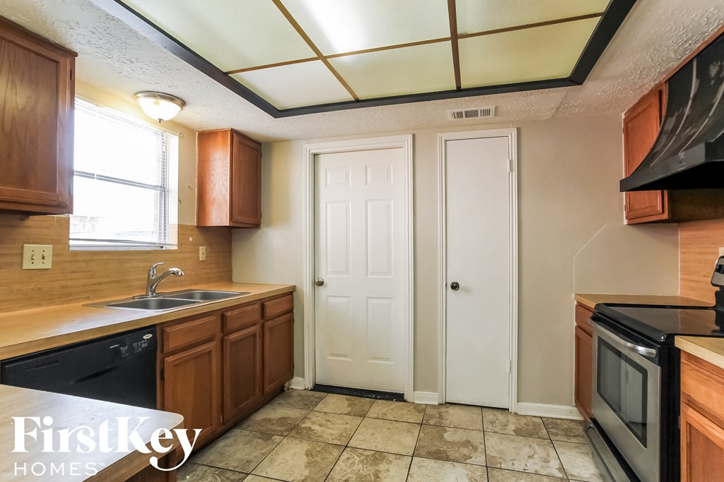 a kitchen with wooden cabinets and a sink and a window