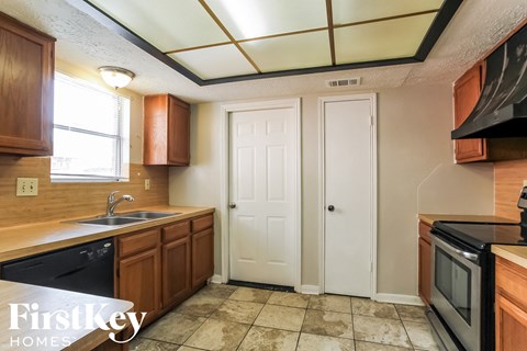 a kitchen with wooden cabinets and a sink and a window
