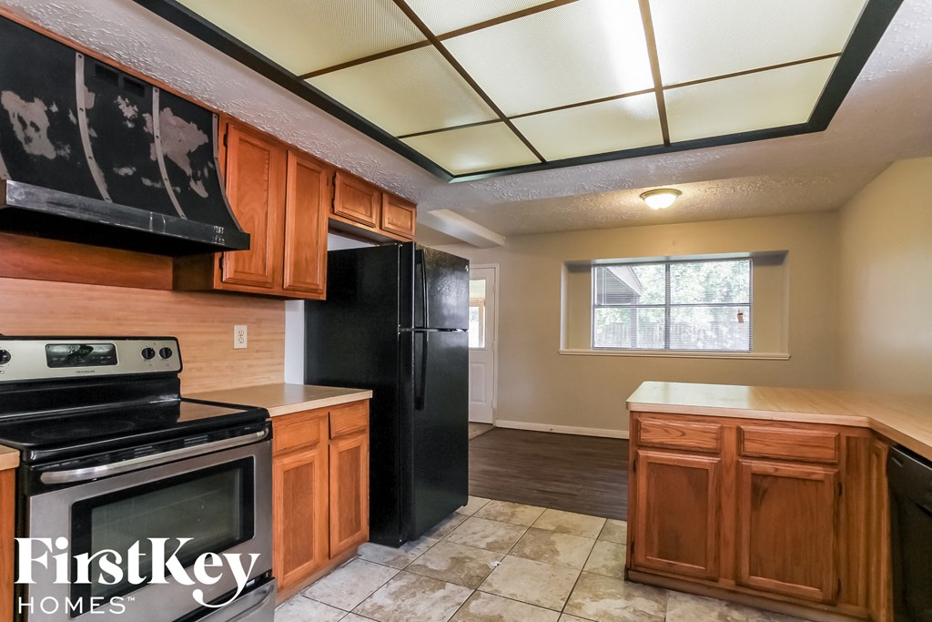 a kitchen with black appliances and wooden cabinets