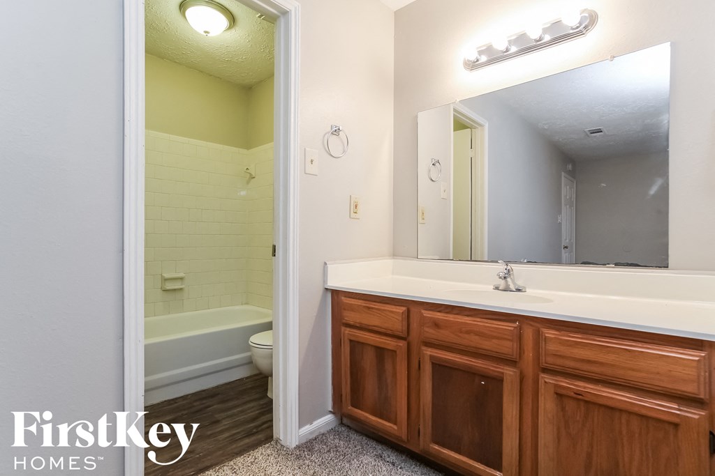 a bathroom with a large mirror and a sink and a toilet