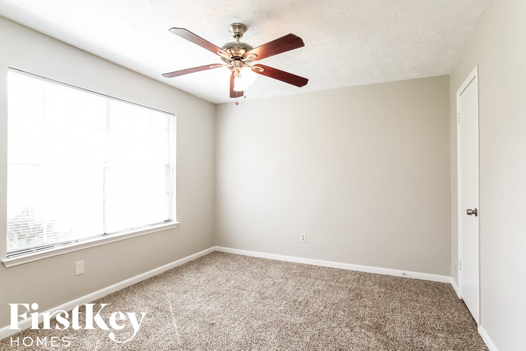 a bedroom with a ceiling fan and a window