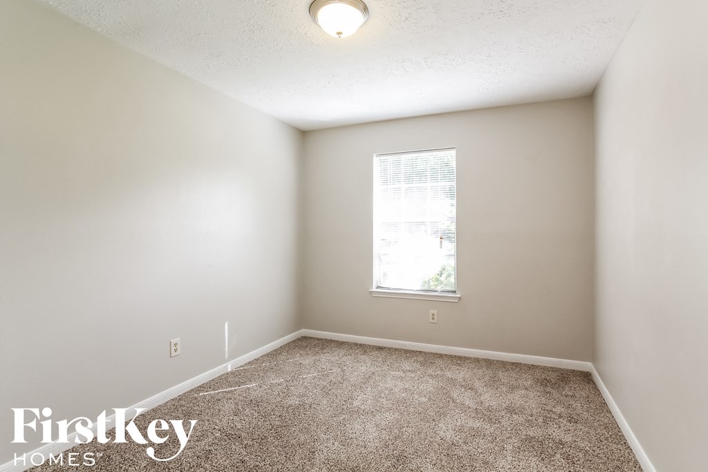 a bedroom with a carpeted floor and a window