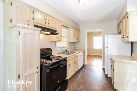 A kitchen with wooden cabinets and a black stove top oven.