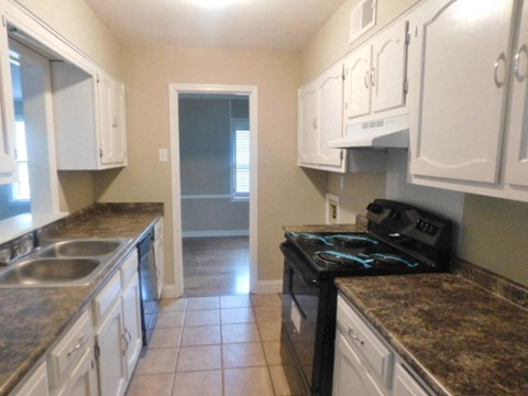 A kitchen with black appliances and granite countertops.