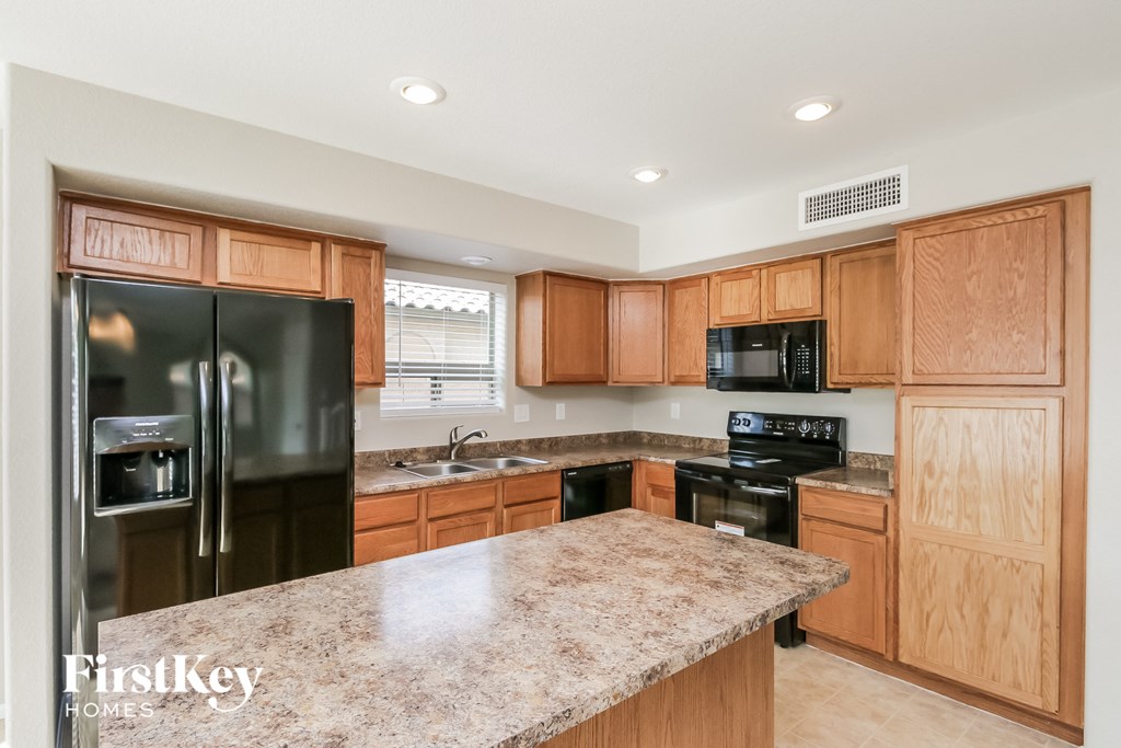 a kitchen with wooden cabinets and black appliances and granite counter tops