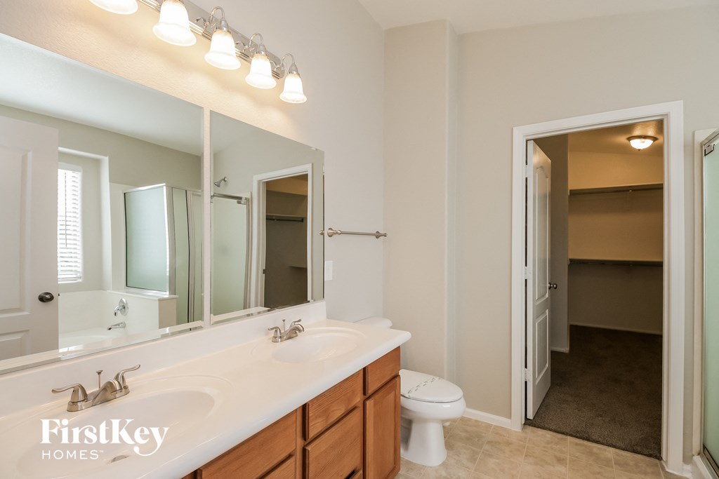 a bathroom with a large mirror and a sink and a toilet
