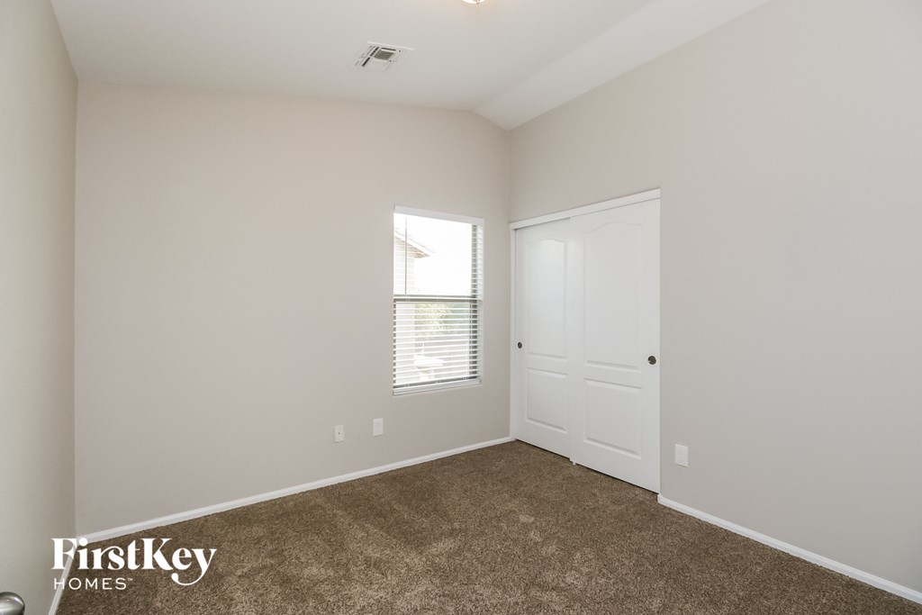 a bedroom with carpet and a door and a window