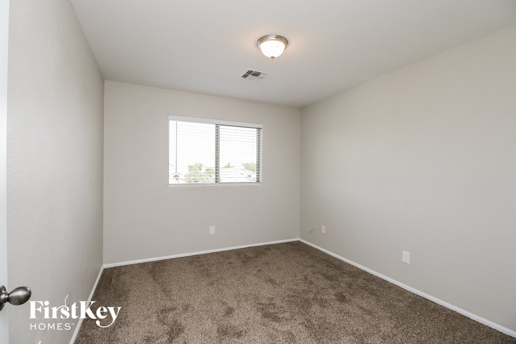 a empty room with carpet and a window