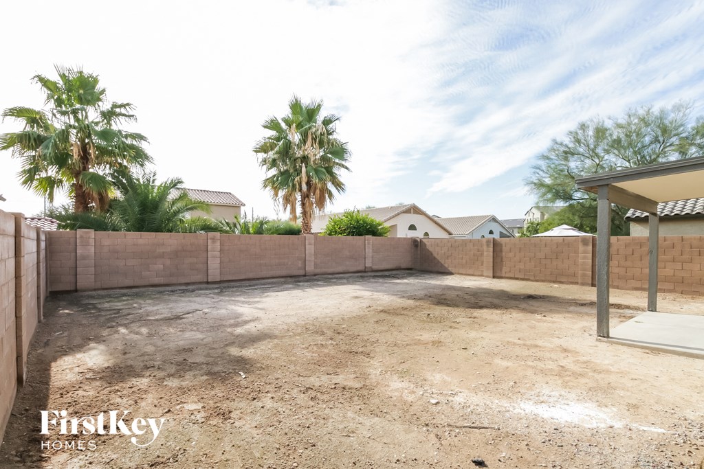 a backyard with a dirt area and palm trees