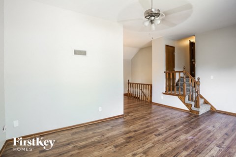 a living room with hardwood floors and a staircase