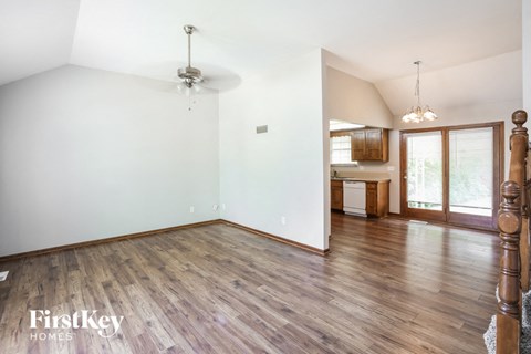 an empty living room with wood floors and white walls