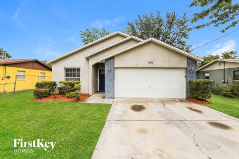 a white house with a white garage door and a green lawn