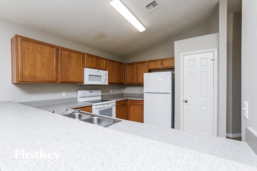 a kitchen with white appliances and wooden cabinets