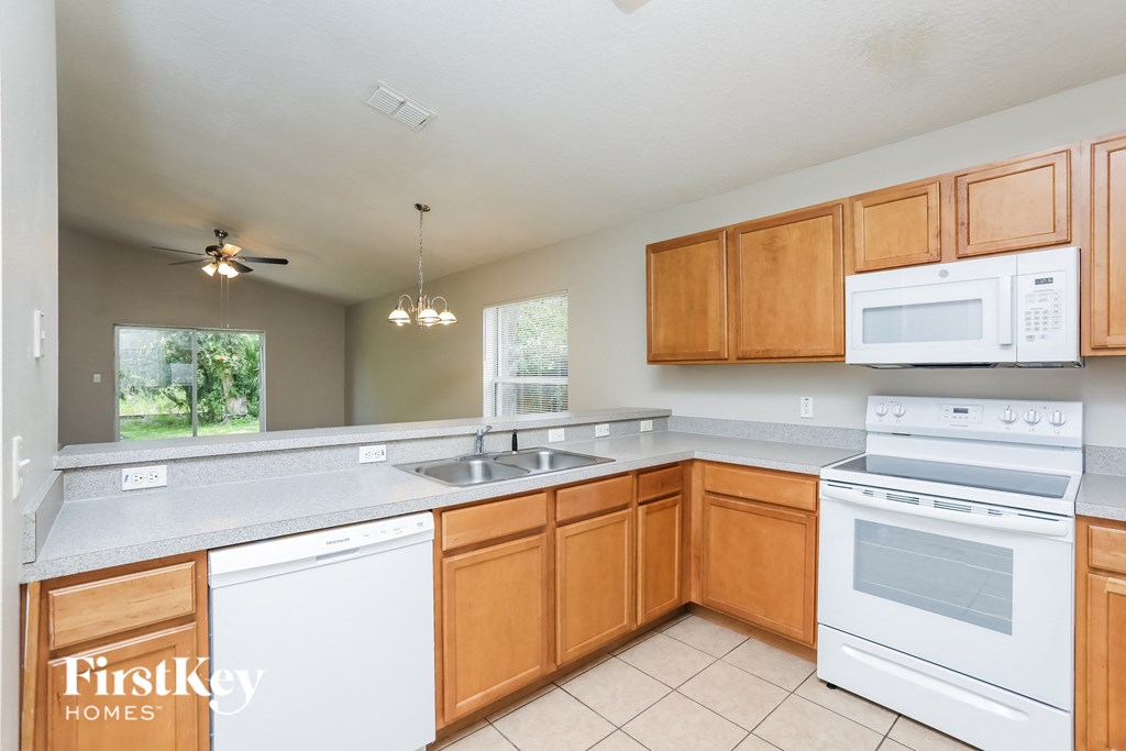 a kitchen with white appliances and wooden cabinets