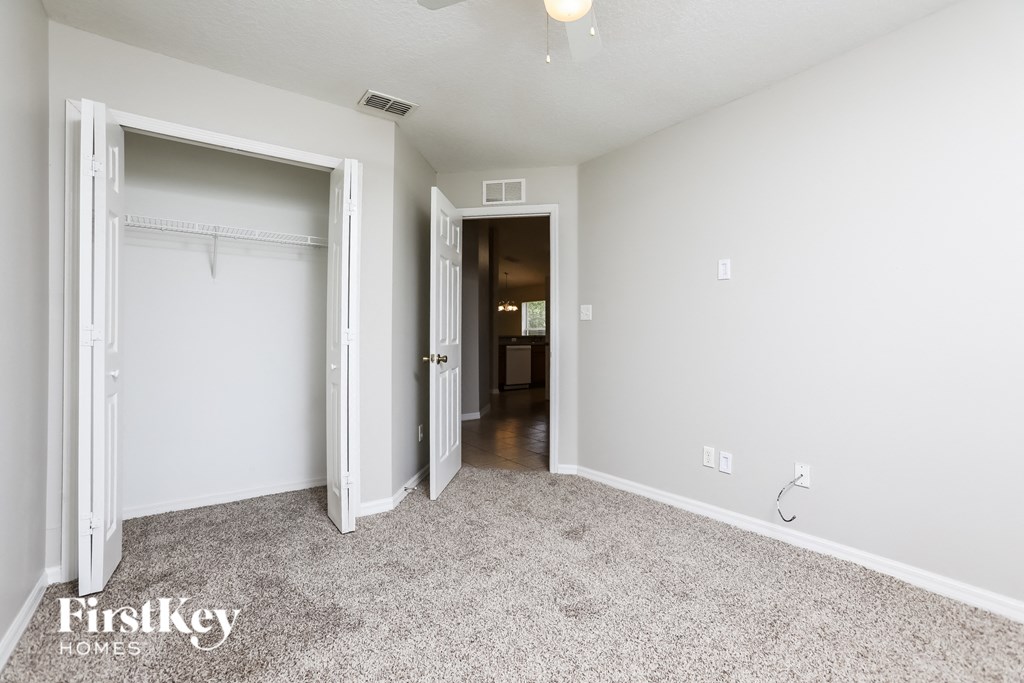 a bedroom with a closet and a door to a hallway