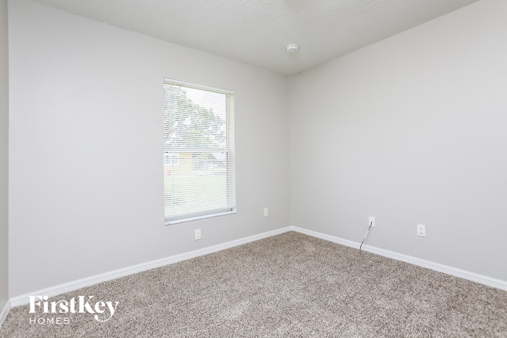 an empty room with carpet and a window