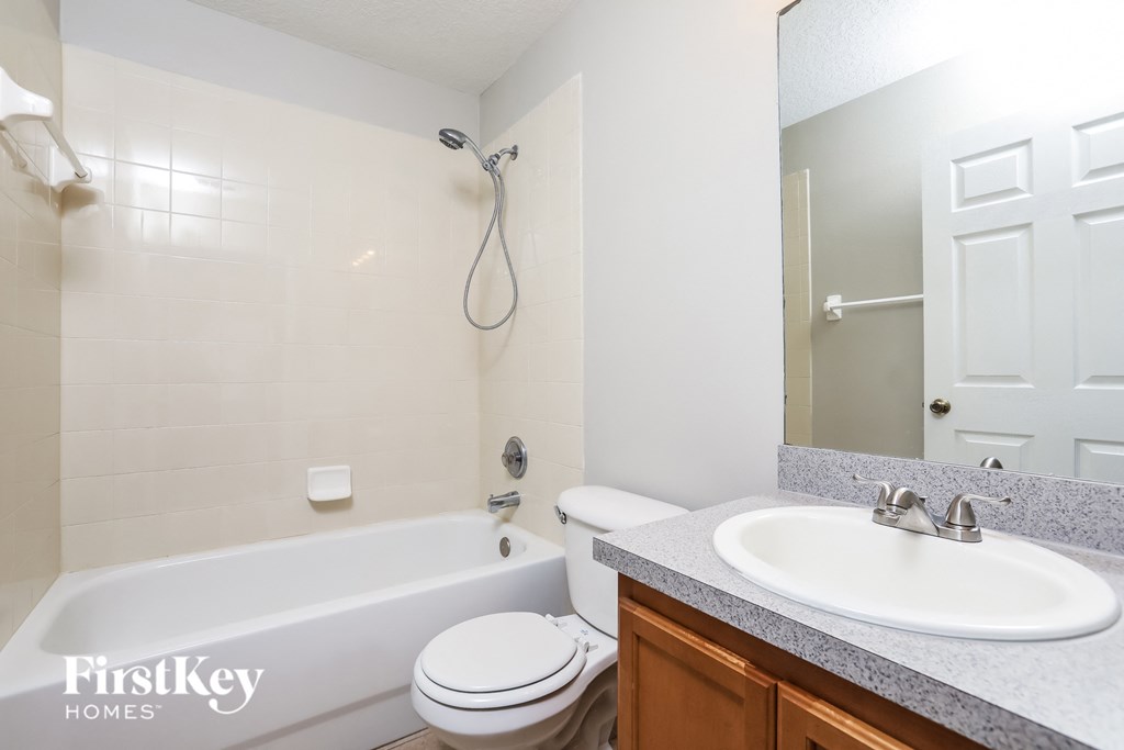 a bathroom with a sink toilet and tub and a mirror