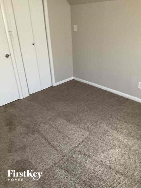 a bedroom with a carpeted floor and a closet