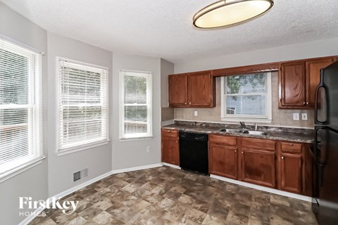 a kitchen with wooden cabinets and a sink and a refrigerator