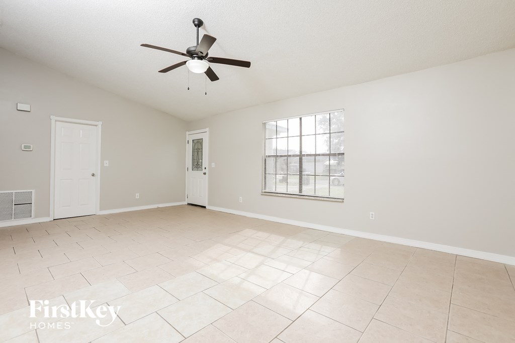 A spacious room with a ceiling fan and a window.
