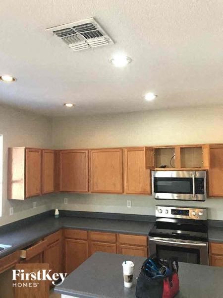 a kitchen with wooden cabinets and a stove and microwave