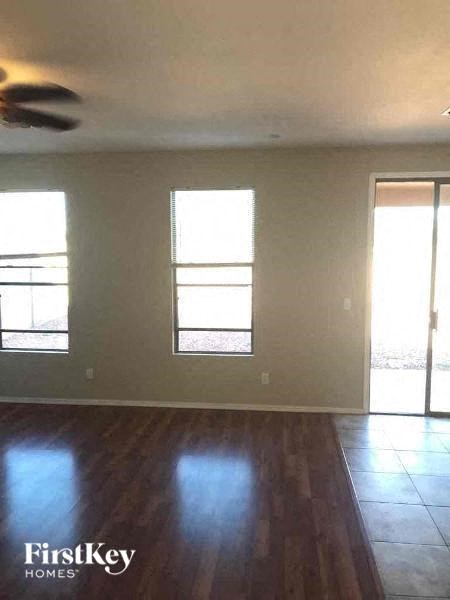 an empty living room with a wood floor and windows