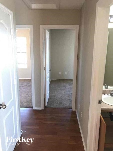 a hallway with a sink and a door to a bathroom