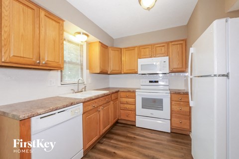A kitchen with wooden cabinets and a white fridge.