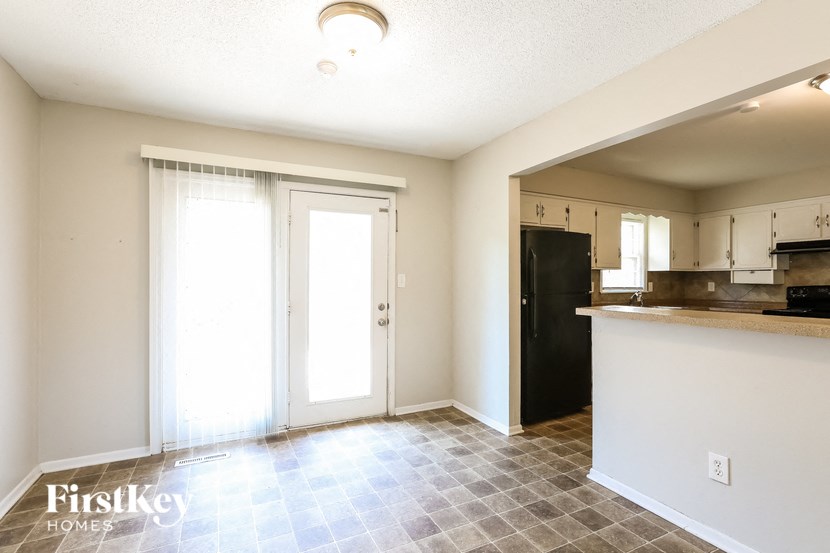 an empty kitchen and living room with white walls and doors