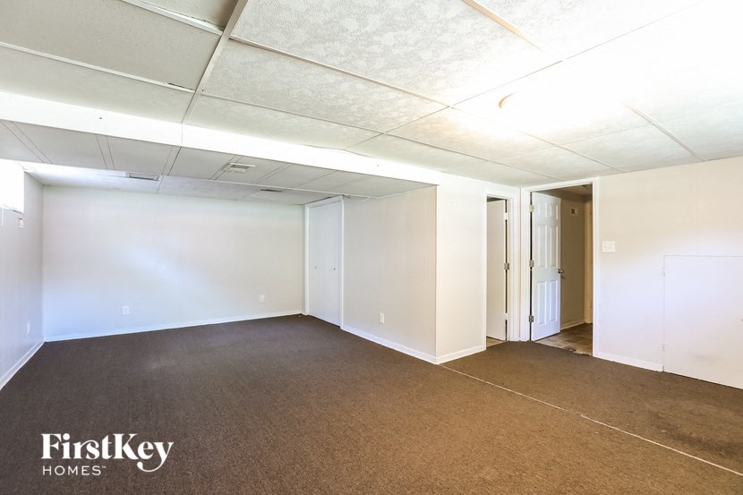 an empty living room with white walls and carpet