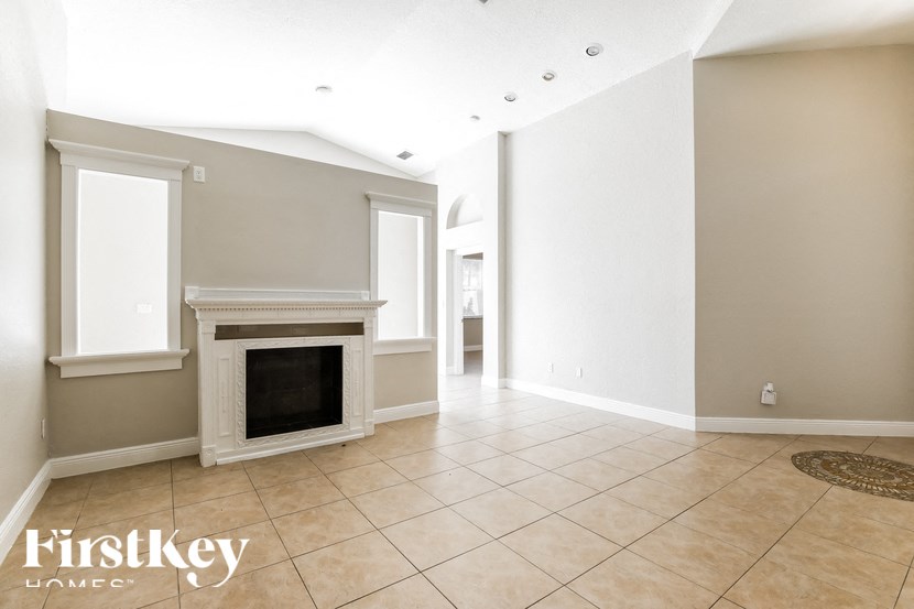a living room with a fireplace and a tiled floor