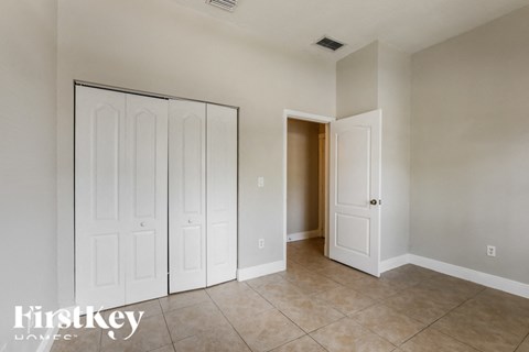 a master bedroom with two closets and a tiled floor